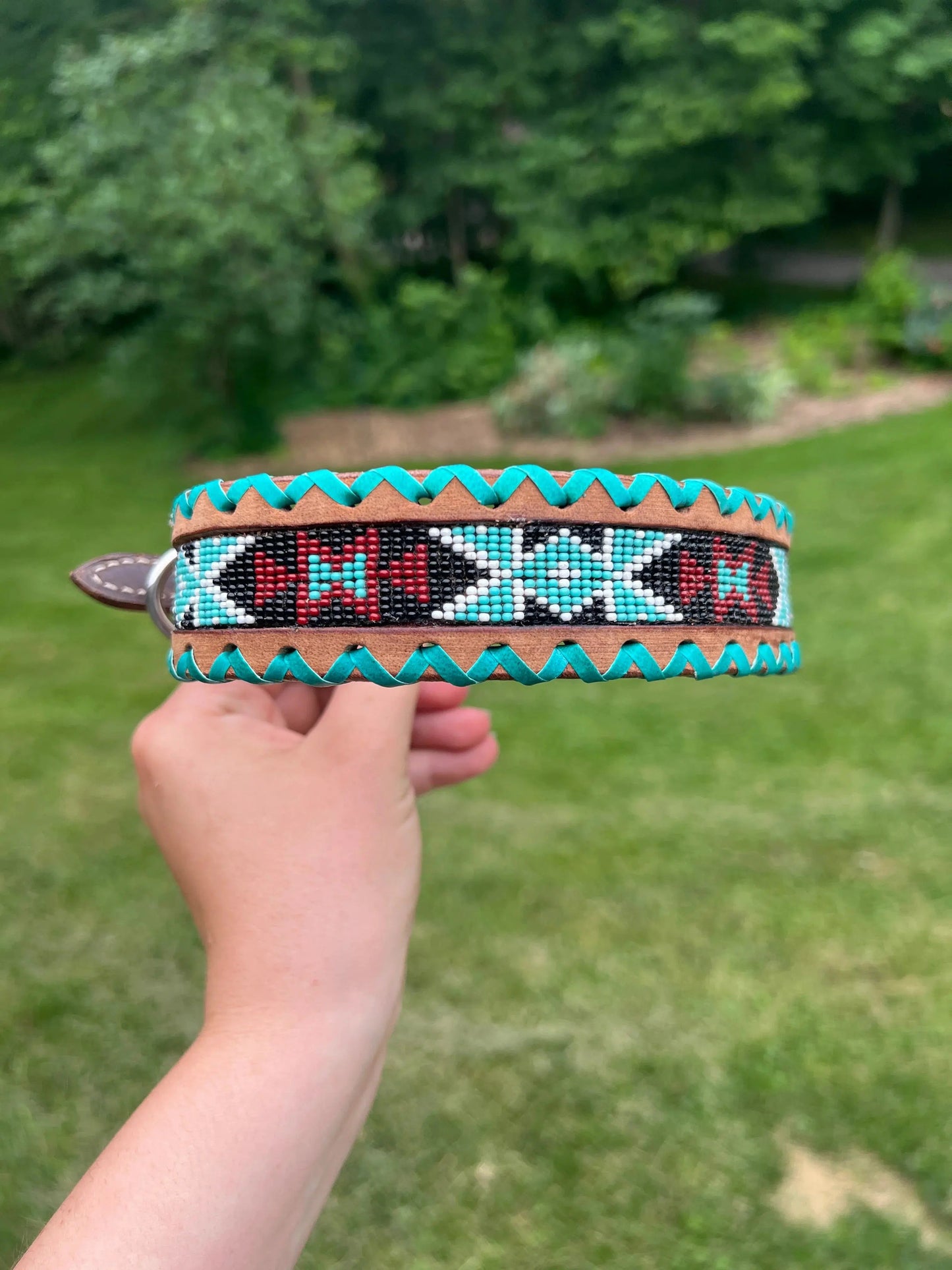 Genuine leather dog collar with teal, white, and burgundy beaded inlay design, a rawhide wrapped edge